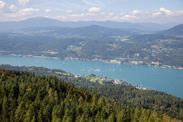 Panoramic top view of the green Austrian Alps, villages and Werthersee lake