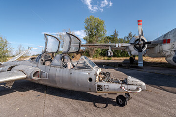 View of the double cockpit of an airplane and a propeller of another, which is stripped and broken