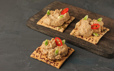 Homemade chicken appetizer pate with crackers on a rustic background