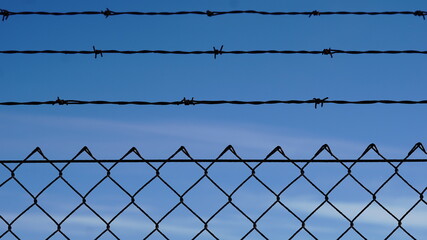 barbed wire fence against sky background