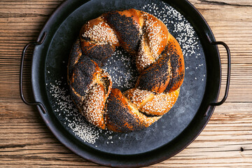 Homemade Easter bread ring with poppy and sesame seeds on wooden table