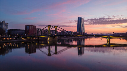 Fototapeta na wymiar Photo of sunrise over the Main river in Frankfurt with bright morning red which is reflected in the water