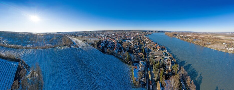 Drone image of wine village Nierstein on the Rhine in blue sky and sunshine with snow covered slopes