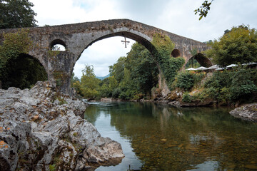 Fototapeta na wymiar beautiful Roman bridge located in Cangas de Onis, Asturias next to the Sella river on a summer day.