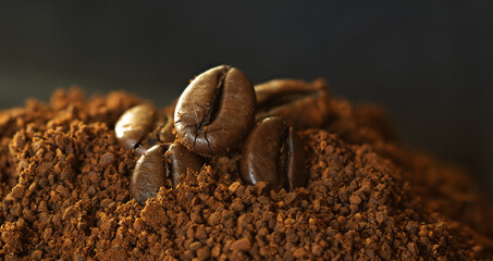 Ground coffee, five coffee beans. Selective focus.