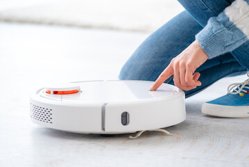 Fototapeta premium Switching on robotic vacuum cleaner in light room