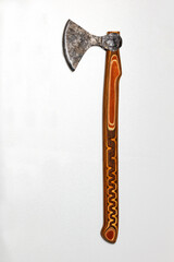 Battle ax of an antique Ukrainian warrior with a carved wooden handle on a gray silver background.