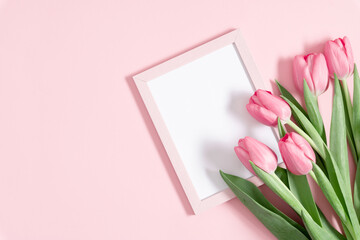 Flowers composition romantic. Flowers pink tulips, photo frame on pastel pink background. Wedding. Birthday. Happy womens day. Mothers Day. Valentine's Day. Flat lay, top view, copy space