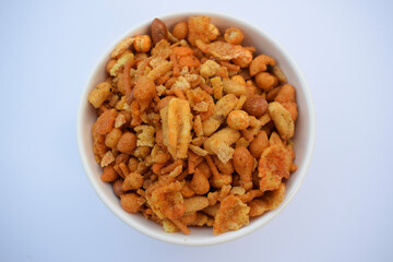 Indian namkeen snacks served in ceramic white bowl on white background isolated. Also known as nimco, namkin, mixture chiwda or nimko