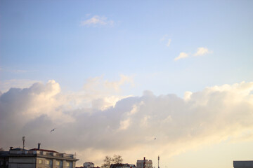 Obraz premium evening clouds over the rooftops of city houses
