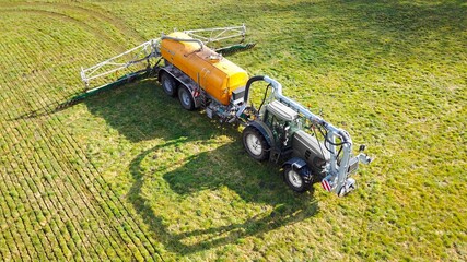 Traktor mit Gülletonne und Schleppschuhverteiler bringt Gülle auf Wiese aus, Industrielle...
