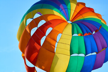 Closeup of paragliding parachute against the blue sky.