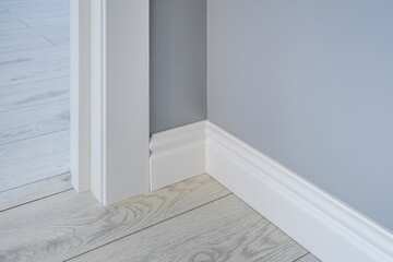 Detail of corner flooring with intricate crown molding and plinth. - obrazy, fototapety, plakaty