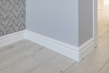 Detail of corner flooring with intricate crown molding and plinth.