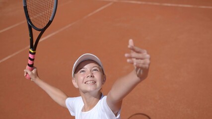 A young tennis player serves in the game.