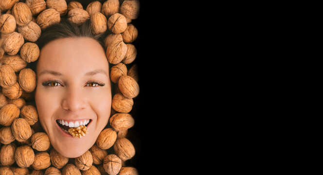 Happy Woman Face With Perfect Smile On A Walnuts Background With Black Advertisement Board For Text. Eating Nuts. Healthy Vegetarian Protein, Nutritious Food. Woman With Strong Teeth And White Smile