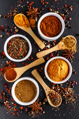 Various spices a vintage spoons on stone table. Colorful Herbal and Spices Oriental marketplace.Top view . Cafe concept. Delicious food delivery.