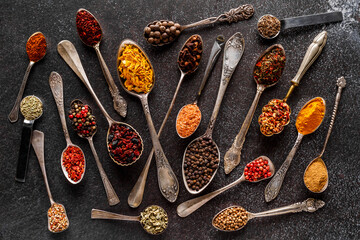 Various spices a vintage spoons on stone table. Colorful Herbal and Spices Oriental marketplace.Top view . Cafe concept. Delicious food delivery.