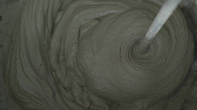 Hand held concrete mixer is mixing a concrete