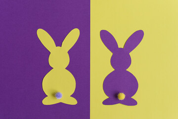 Yellow and purple paper Easter bunnies on yellow and purple background. Creativity concept. Easter decor