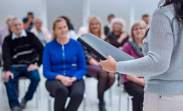 teacher with a folder in his hand teaches elderly people busines