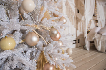 Christmas pastel decorations on white christmas tree.shiny sparkling holidays balls on fir tree.Creative Winter Christmas interior. Gold, beige, silver and white ornaments.