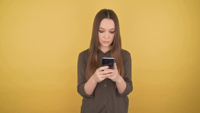 Young business woman looks into the phone with a calm face. 4K