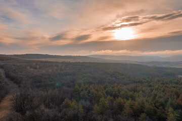 Naklejka na ściany i meble Beautiful sunset overt the forest from drone view