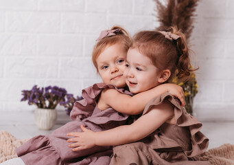 Fototapeta na wymiar Two cute little girls cuddle and smile