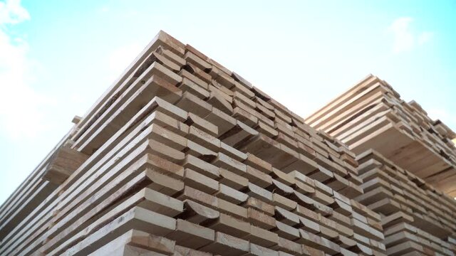 Stock of Lumber. Rafters for building a house. Packs of lumber at the Sawmill. Big framework. Natural materials from wood. Knots on Lumber. Pine Boards in large packages. Manufacture of wooden product