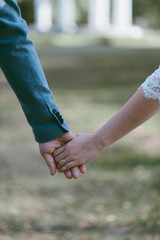 man and woman hold hands. Hands close up on a background of green grass
