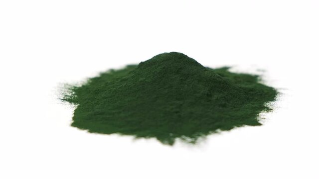 Powder from Spirulina algae on isolated white background spinning right. Nutritional supplements, vitamins and health concept