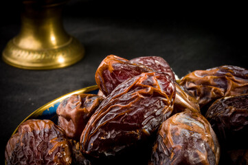 Big luxury dried date fruit in bowls on a linen napkin, kurma ramadan kareem concept, close up.