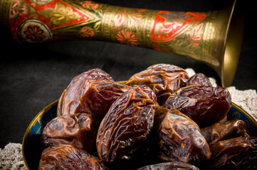 Big luxury dried date fruit in bowls on a linen napkin, kurma ramadan kareem concept, close up.