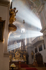 rays of sunshine filter through the smoke from incense in an old cathedral