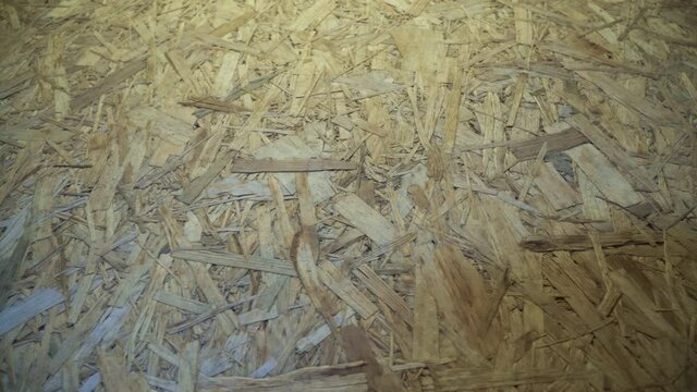 OSB board stored in a warehouse. Sheet building material for the construction of partitions. Wooden OSB board for building a house.
