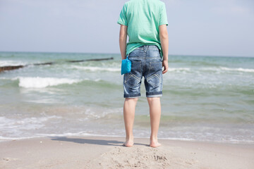 Strand Person von hinten am Wasser