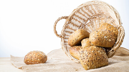 Whole wheat bread. Fresh loaf of rustic traditional bread with wheat grain ear or spike plant on linen texture background. Rye bakery with crusty loaves and crumbs. Homemade baking.
