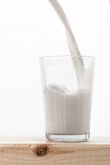 milk is poured into a glass faceted glass, which stands on a wooden table