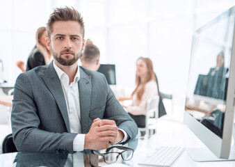 smiling entrepreneur sitting at an office Desk