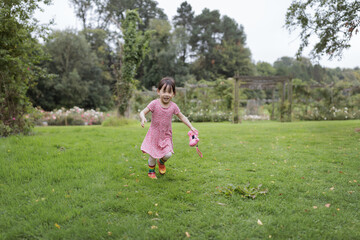 young girl running in the summer garden in the morning
