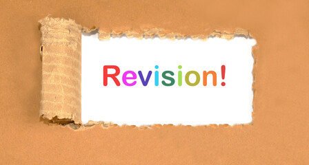 revision word written on torn cardboard on a white background
