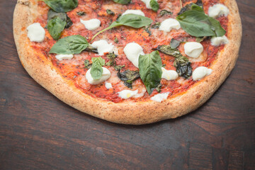 Home made pizza on dark wooden background