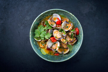 Modern style traditional Italian venus clams soup with tomatoes and garlic in a wine jus as top...