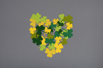 St Patricks Day. Heart shape of clover leaves on gray background.