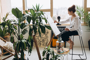 Side view of female artist painting on canvas