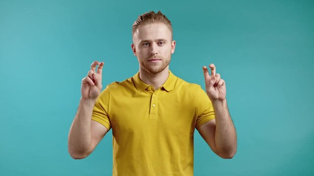 Handsome man showing with hands and two fingers air quotes gesture, bend fingers isolated over blue background. Not funny, irony and sarcasm concept.