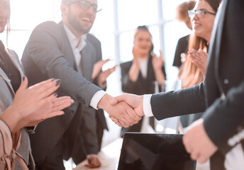 smiling businessman shaking hands with his business partner.