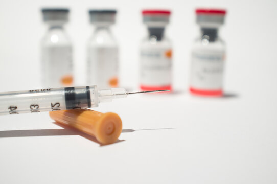 Uncovered syringe and vaccine ampules or glass vials