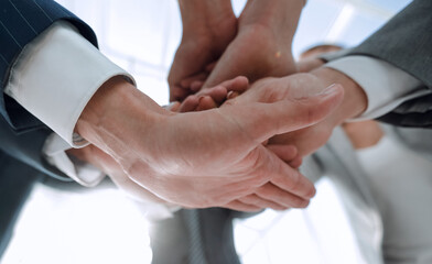 business people folding their hands together.